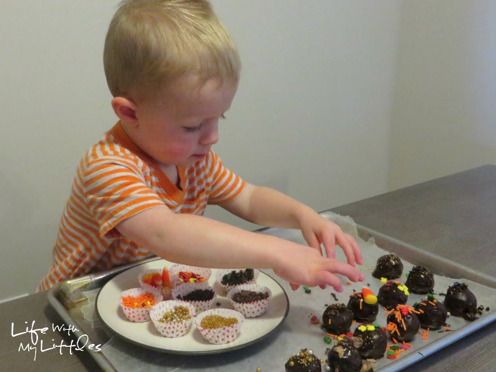 Here's an easy way to get your toddler involved in Thanksgiving baking by decorating OREO Cookie Balls! 