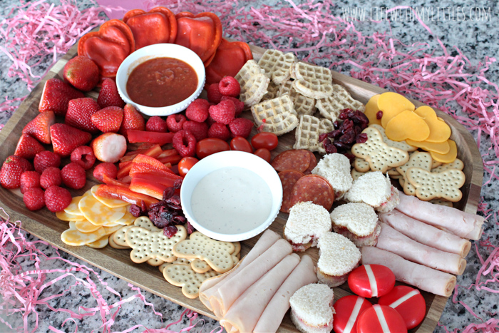 This kid-friendly Valentine's Day charcuterie board is such a fun idea for lunch or dinner. It's easy to put together, and there are lots of great pink and red food suggestions included so you can make your own! Making a charcuterie board for kids has never been easier!