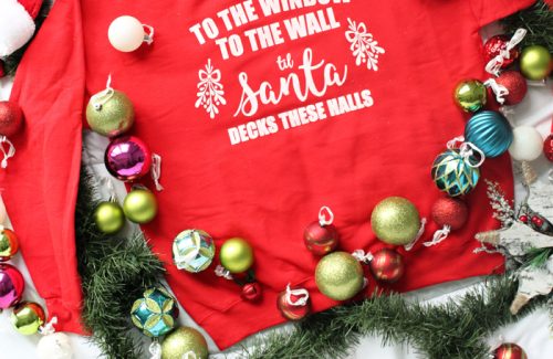 "To the Window, to the Wall, 'Til Santa Decks these Halls" Christmas parody sweatshirt that you can DIY! All you need is a Cricut, vinyl, screen printing supplies, and a sweatshirt to make this hilarious holiday sweater.