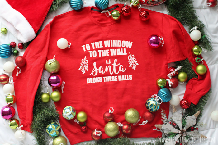 "To the Window, to the Wall, 'Til Santa Decks these Halls" Christmas parody sweatshirt that you can DIY! All you need is a Cricut, vinyl, screen printing supplies, and a sweatshirt to make this hilarious holiday sweater.